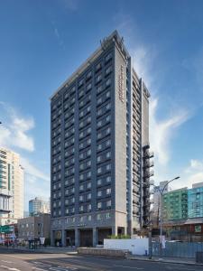a tall building in the middle of a city at Uljiro Coop Residence Dongdaemun in Seoul