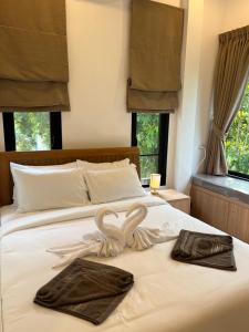 a bed with two swans made out of towels at Rancho Relaxo Pool Villa in Ban Tai +14 photos