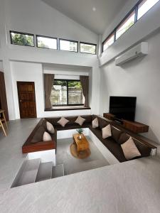 a large living room with a couch and a tv at Rancho Relaxo Pool Villa in Ban Tai