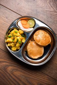 a plate of food with pancakes and vegetables on a table at Aras Homestay New Hampi in Hampi