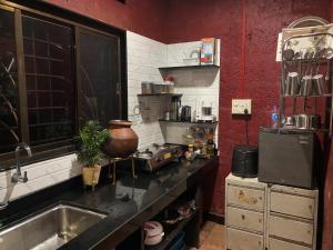 a kitchen with a sink and a counter top at Mangalmurti Farmstay in Pendur