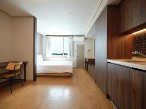 a bedroom with a bed and a desk and a kitchen at Western Coop Hotel & Residence Dongdaemun in Seoul +33 photos