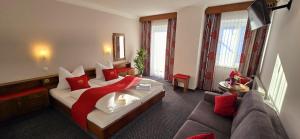 a hotel room with a bed and a couch at Hotel Rossmann in Greifenburg