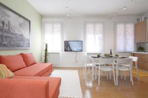 salon z pomarańczową kanapą i stołem w obiekcie Venice Murano Flat w mieście Murano
