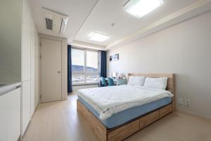 a bedroom with a bed and a large window at 김천 포유스테이 in Oksan