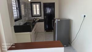 a kitchen with a refrigerator and a sink at Suneetha Presidency in Amalāpuram