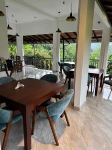 a dining room with a wooden table and chairs at Rainforest mountain resort in Deniyaya
