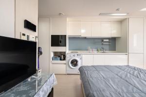 a white kitchen with a washing machine and a washer at 김천 포유스테이 in Oksan