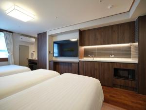 a hotel room with two beds and a flat screen tv at Western Coop Hotel & Residence Dongdaemun in Seoul