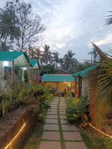 a garden with a walkway next to a building at Bhakti Yoga Ashram in Canacona