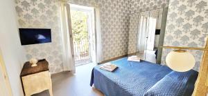 a bedroom with a blue bed and a window at Corso Vittorio Elegant Suites Lipari in Lipari