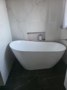 a white bath tub sitting in a bathroom at Treasure in Karabah in Queanbeyan