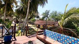 a couch sitting on a deck with palm trees at Private Beachfront Home-Ocean View-Total Privacy in Ampeni +16 photos