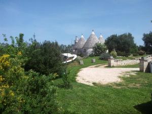 a view of a garden with a house in the background at Trulli La Gufa in Ostuni
