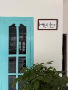 a blue door with a sign above a plant at Villa mud apples varkala in Varkala