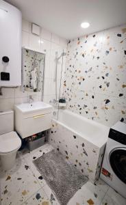 a bathroom with a sink and a tub and a toilet at Geese apt in Kremenchuk