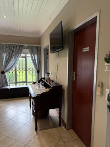 a living room with a piano and a television at ARK Guesthouse in Potchefstroom