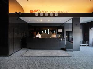 a person standing behind a counter in a building at Western Coop Hotel & Residence Dongdaemun in Seoul