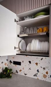 a kitchen with white plates and bowls on shelves at Geese apt in Kremenchuk +7 photos