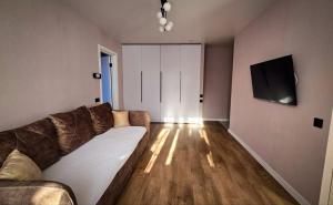 a living room with a couch and a flat screen tv at Geese apt in Kremenchuk