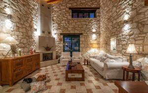 a large living room with a stone wall at Anassa Villa in Mouzákion