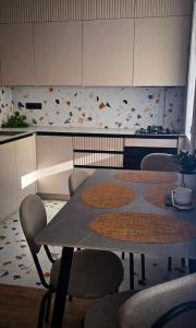 a kitchen with a table and chairs in a room at Geese apt in Kremenchuk