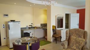 a kitchen with a table and a desk with a chair at Alexander The Great Hotel in Alexandria