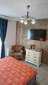 a bedroom with a bed and a tv and a chair at Chic Flat - 24 H self checkin-free parking in the yard in Floreşti