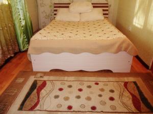 a small bed in a room with a rug at Ахметова 10 in Krasnoye Pole