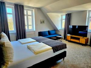 ein Schlafzimmer mit einem großen Bett und einem Fernseher in der Unterkunft Hotel Starke in Brilon