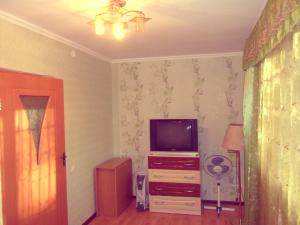a living room with a tv on a dresser at Ахметова 10 in Krasnoye Pole