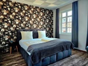 ein Schlafzimmer mit einem Bett und einer floralen Wand in der Unterkunft Hotel Starke in Brilon