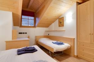a bedroom with two beds and a window in a attic at Apartments Trettel in Tesero