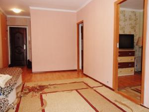 an empty living room with a couch and a television at Ахметова 10 in Krasnoye Pole