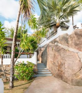a staircase leading up to a house with palm trees at Eden's Holiday Villas in Mahe