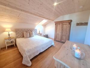 a bedroom with a white bed and a wooden floor at CHIEMSEE MOUNTAIN LODGE - adults only - Eleganz auf 95qm - Traumblick - XL-Balkon - Privatsphäre in Bernau am Chiemsee