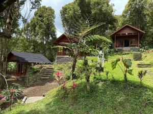 a couple of small buildings in a garden at Kubu Waru Bali in Munduk