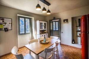 a kitchen with a table and chairs and a red refrigerator at Il Giardino di Nesso in Nesso