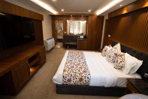 a hotel room with a bed and a flat screen tv at Sindh Resorts in Srinagar