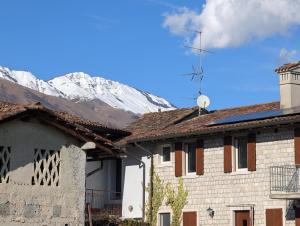 Ein Gebäude vor einem schneebedeckten Berg im Hintergrund in der Unterkunft Ai Foresti in Castello dʼAviano