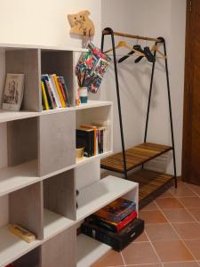 ein Raum mit weißen Regalen mit Büchern in der Unterkunft Ai Foresti in Castello dʼAviano