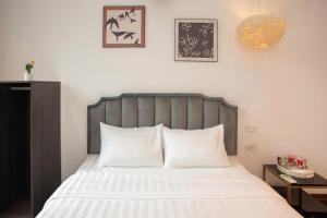 a bedroom with a large bed with white sheets at Luma Boutique Hotel in Hanoi