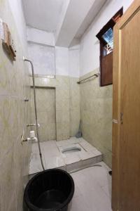 a bathroom with a black toilet in a room at Anigo Cottage Naharlagun in Bacha