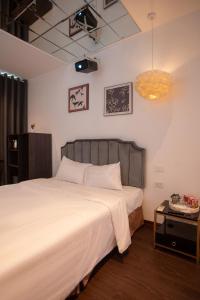 a bedroom with a large bed and a table at Luma Boutique Hotel in Hanoi +84 photos