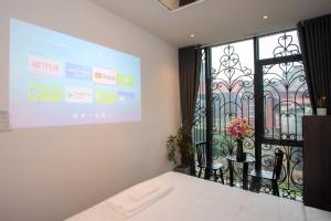 a projection screen in a room with a table and chairs at Luma Boutique Hotel in Hanoi