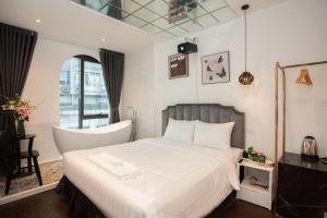 a bedroom with a white bed and a window at Luma Boutique Hotel in Hanoi