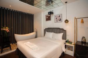 a bedroom with a large white bed in a room at Luma Boutique Hotel in Hanoi