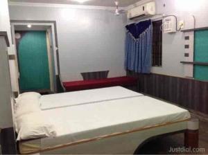a hospital room with two beds and a green door at Le Palace in Gūduvāncheri