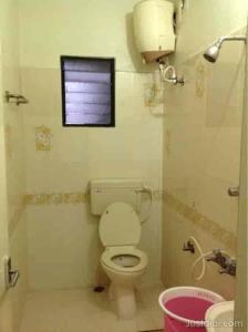 a bathroom with a toilet and a window at Le Palace in Gūduvāncheri