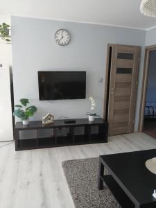 a living room with a flat screen tv on a wall at Duży Apartament 75m2 in Wągrowiec